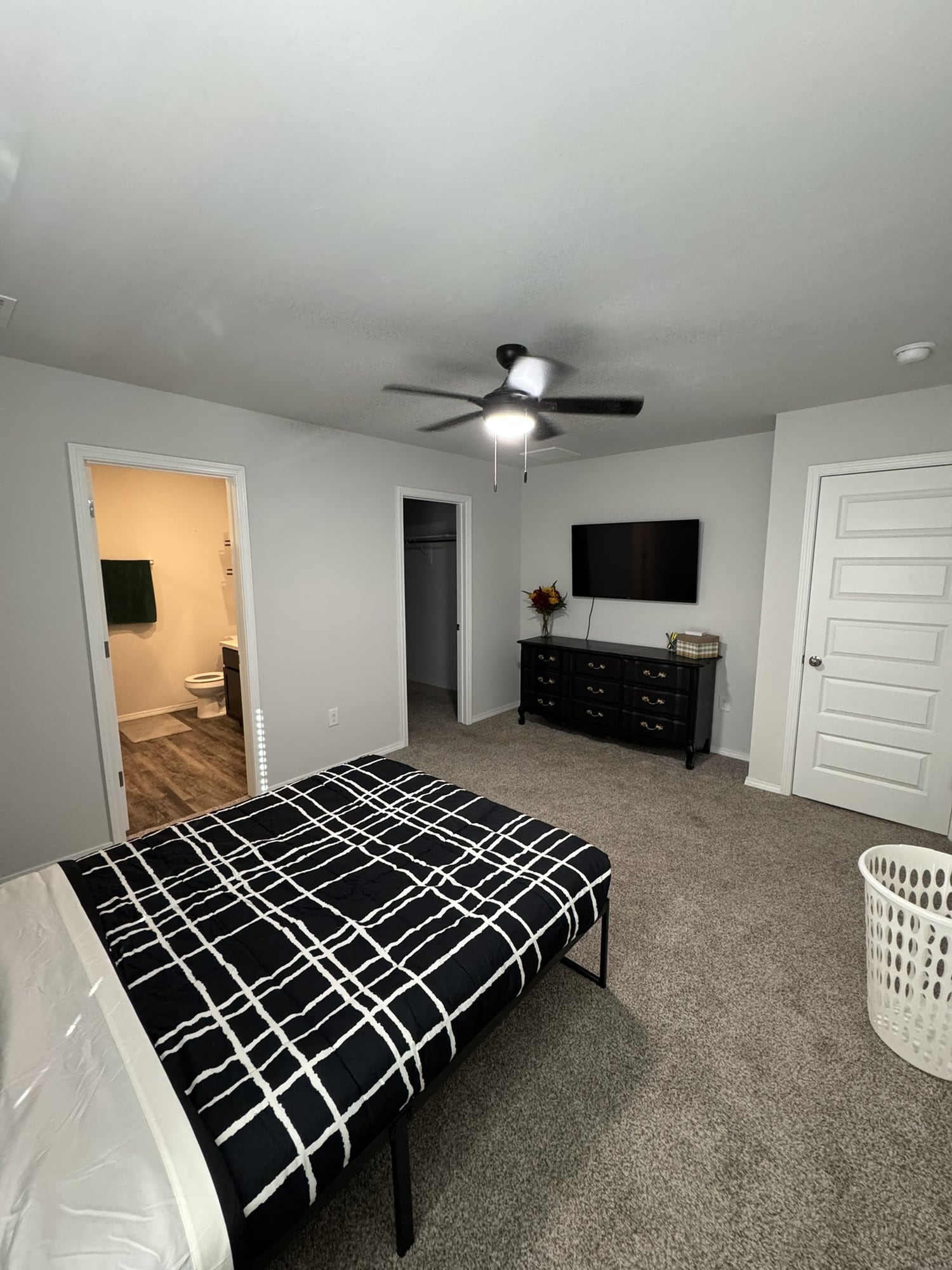 Furnished bedroom with television, closet, and adjoining bathroom